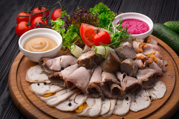 Meat appetizer antipasto on black wooden background