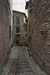 Fototapeta premium Spectacular traditional italian medieval alley in the historic center of beautiful little town of Spello (Perugia), in Umbria region - central Italy