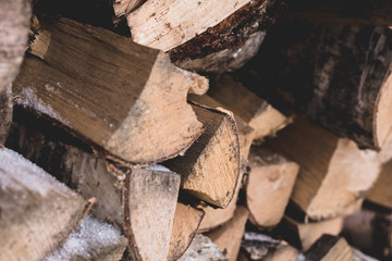 Firewood for kindling the fireplace are lying outdoor in the winter