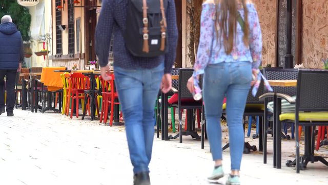 Unrecognizable people passing besides parisian cafe terrace facing the rainy wet street, Paris, France