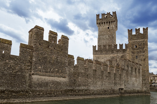 Scaliger castle is historical landmark of the city Sirmione in Italy on the Lake Garda. View of the old castle in a small Italian town.