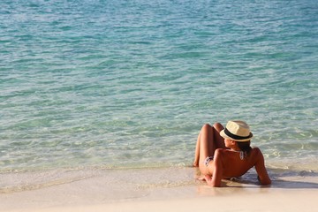 Young fashion woman relaxing on warm tropical beach