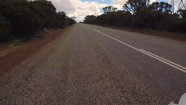 Gerade Fahrstrecke mit einer leichten Rechtskurve in einem PKW auf einem Highway in West-Australien mit Kamerablickwinkel nach vorne