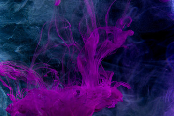 Color paint drops in water. Ink swirling underwater.