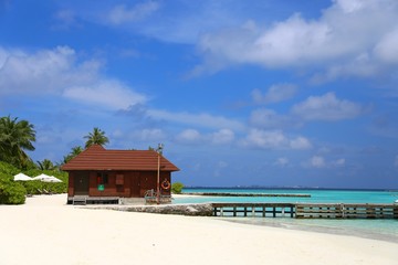 pier on a tropical island with a blue sky on a sunny day. White sand