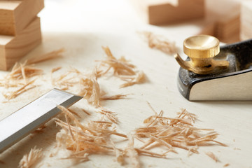DIY concept. Woodworking and crafts. Chisel. plane and stock on the workbench. Top view. Wooden background.