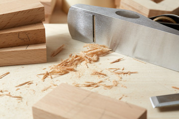 DIY concept. Woodworking and crafts. Chisel. plane and stock on the workbench. Top view. Wooden background.