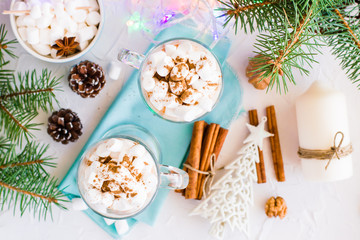 Hot cocoa with marshmallow and ground cinnamon in glasses in Christmas decorations. Top view