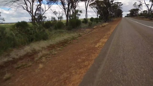 Gerade Fahrstrecke auf einem Highway in West-Australien mit Kamerablickwinkel nach links auf den Seitenstreifen ohne Gegenverkehr