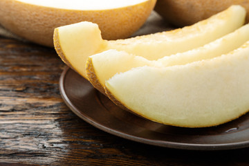 Juicy ripe melon cut into slices on  wooden table