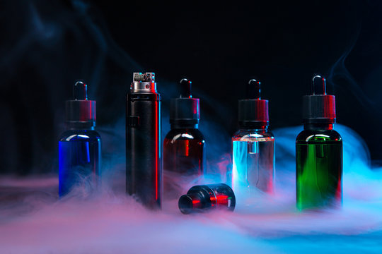 jars of liquids for vape in multi-colored smoke