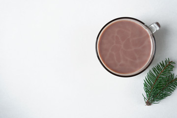 Obraz na płótnie Canvas Winter drink. Warm cocoa with milk on a white background. Decor with fir branches. Flat lay. Morning light. Place for text
