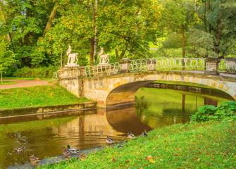 Fototapeta na wymiar bridge with sculptures in old autumn park