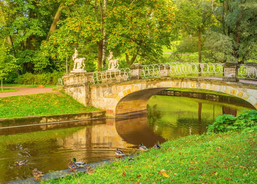 bridge with sculptures in old autumn park