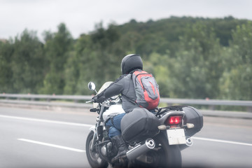 Biker in helmet and leather jacket racing on the road