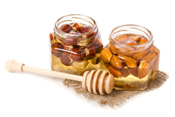 A honey jar with a spoon for honey nuts