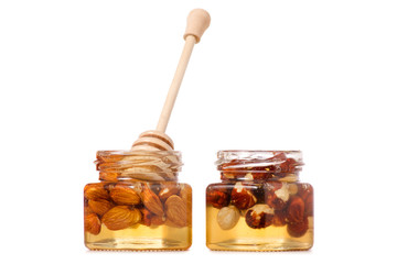 A honey jar with a spoon for honey nuts