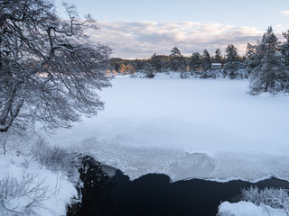 The cold snow winter lake in evening light