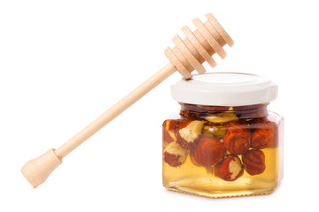 A honey jar with a spoon for honey nuts