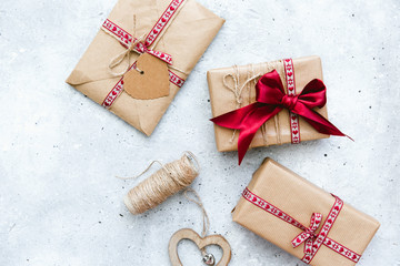 Gift wrapped boxes and red decorative heart on vintage background
