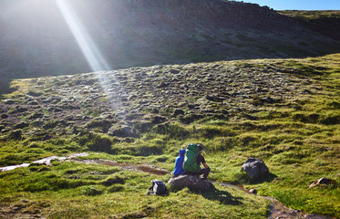 couple hikers having rest on the trail in Valley of the river of Hveragerdi Iceland. Hiking Tour of Reykjadalur Hot Springs