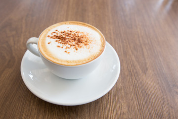 hot cappuccino on wooden table 