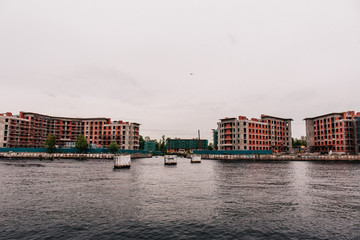 Naklejka premium construction of new houses on the river bank on a cloudy day