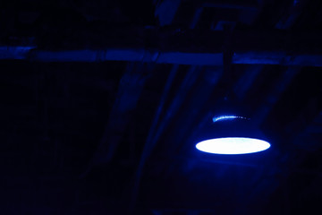 Old hanging lamp in the factory at night. Industrial night scene. Attic. Interior style with space for text.