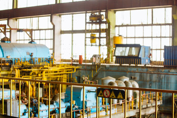 Machine room in thermal power plant with electric generators and turbines. Modern factory. Equipment, pipes at the power plant.