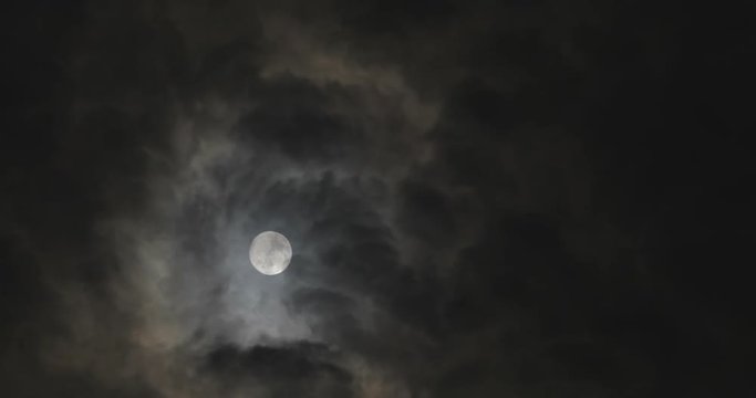 Full moon at night with moving clouds