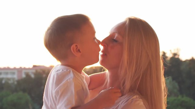 Portrait of happy caucasian family at sunset. Laughing mother and son in sunset. Slow Motion