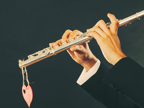 Male flutist with flute and heart. Love melody