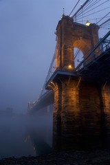 cincinnati, ohio and covington kentucky riverfront and bridges in the fog on misty day at dusk