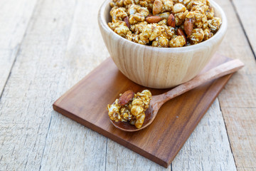 Popcorn caramel mix macadamia and almond taste on wood table with copy space.