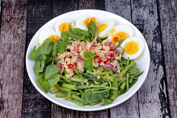 Spicy Chinese morning glory salad with boiled egg topped pork chops.