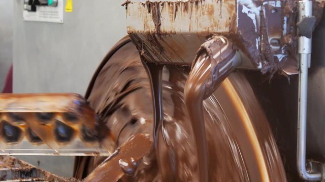 a machine keeps chocolate liquid at a factory that makes hand made chocolates