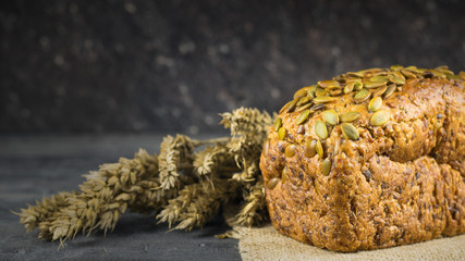 Ears of wheat next to the bread flour on a wooden table.