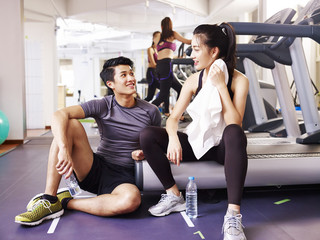 asian young people talking while resting in gym