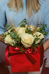 girl holding beautiful mix white roses bouquet in red box