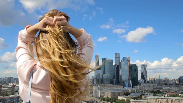 Young woman looking at cityscape and skyscrapers