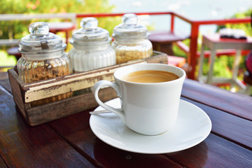 Fototapeta na wymiar Cup of Coffee on table over mountains landscape with sunlight Beauty nature background