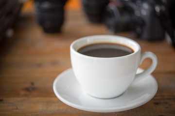 White coffee mug on patterned old wooden floor.