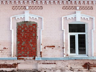 fragment the facade of the building with a window bricked up. Old brick wall with Windows.