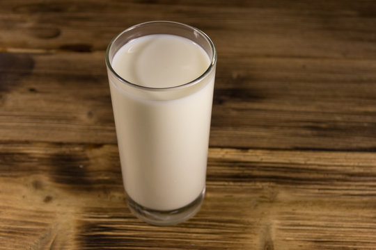 Glass of milk on wooden table