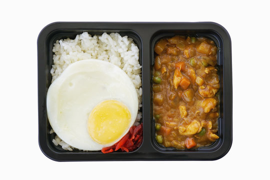 Japanese Curry Chicken with rice and fried egg in black plastic tray, ready meal for takeaway ,included clipping path