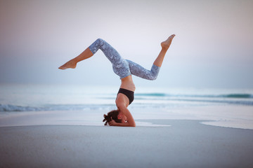 Summer yoga session on a beautiful golden beach of Maldives yoga tour, Salamba Sirsasana - supported headstand