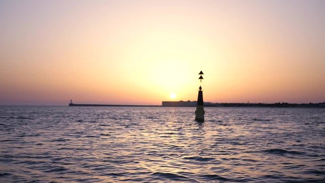 A buoy in the sea against a beautiful sunset on the horizon. HD, 1920x1080, slow motion