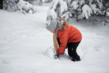 Fototapeta na wymiar winter fun. the boy sculpts the snowman.
