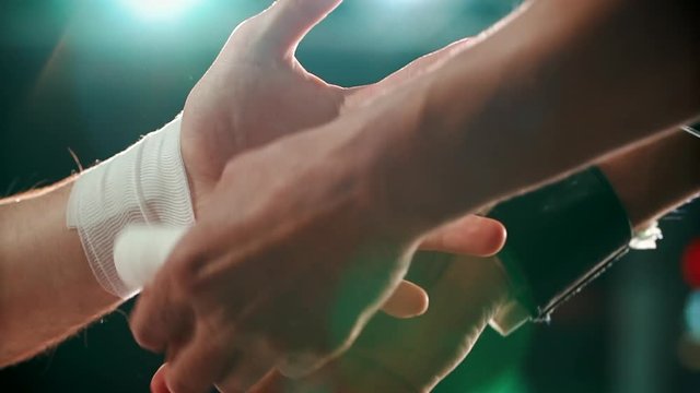 Close up boxing trainer or manager wrapping hands of a boxer reparing for boxing match