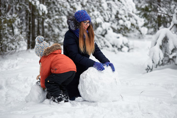 Fototapeta na wymiar winter fun. a girl and a boy making snowballs.